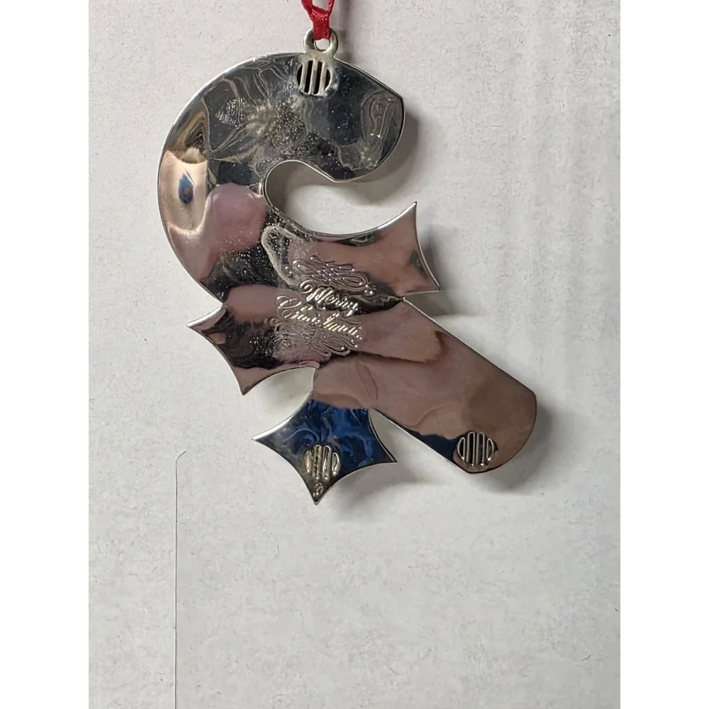 silver-plated Christmas ornament shaped like a candy cane with a holly design